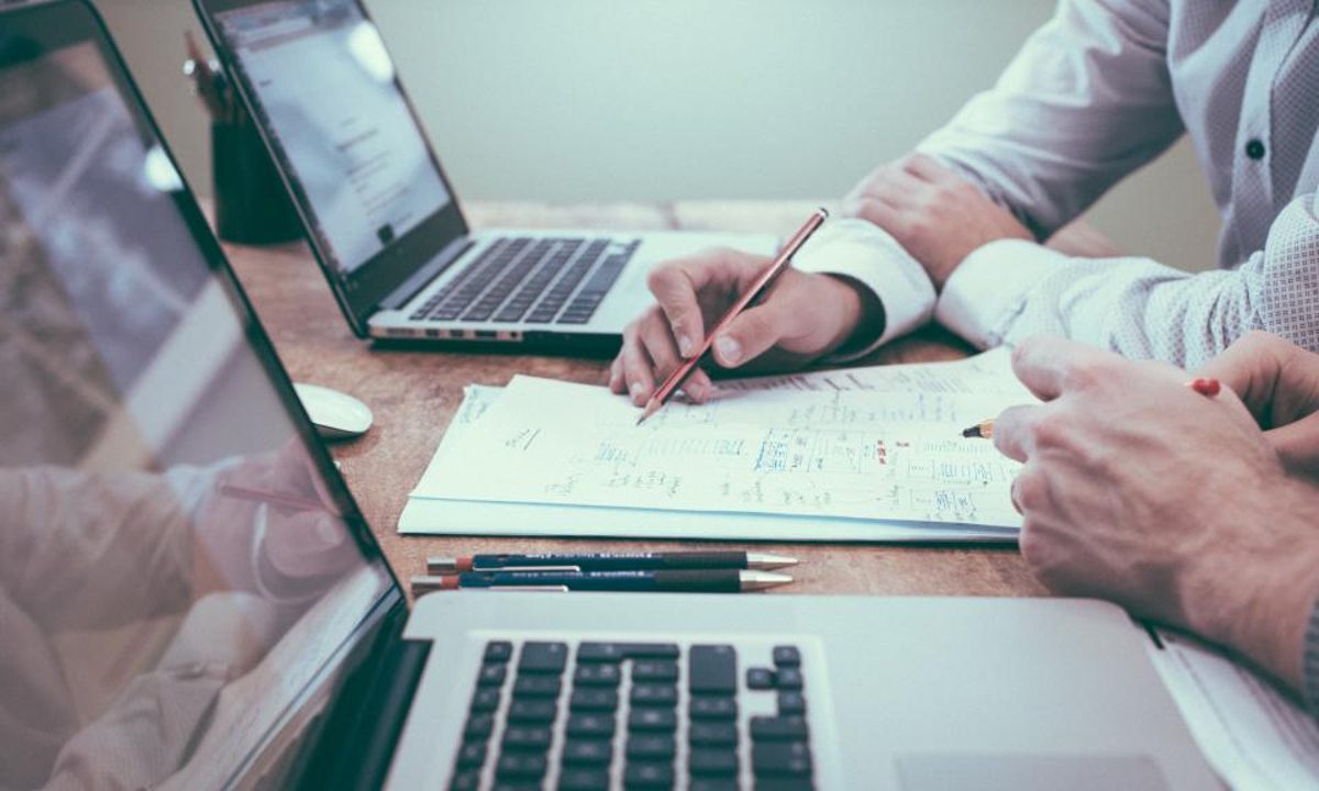 Consultants reviewing management system documentation at a desk